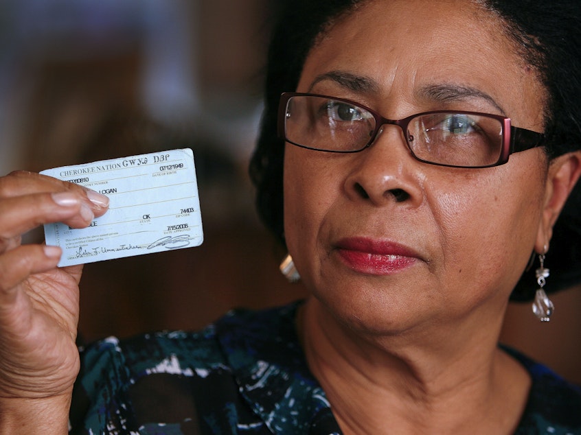 caption: Rena Logan, a member of a Cherokee Freedmen family, shows her identification card as a member of the Cherokee tribe at her home in Muskogee, Okla., in this photo from October 2011. She is among the some 8,500 people whose ancestors were enslaved by the Cherokee Nation in the 1800s.