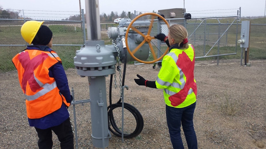 caption: Klapstein (left) and Johnston cut through chains to get access to Enbridge pipelines near Leonard, Minnesota.