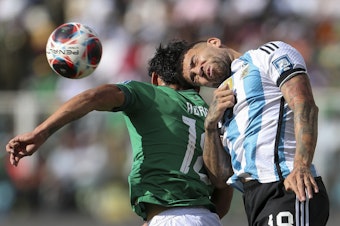 caption: Argentina's Nicolás Otamendi goes for a header with Bolivia's Victor Ábrego during a qualifying match for the FIFA World Cup 2026 at Hernando Siles stadium in La Paz, Bolivia, on Sept. 12.