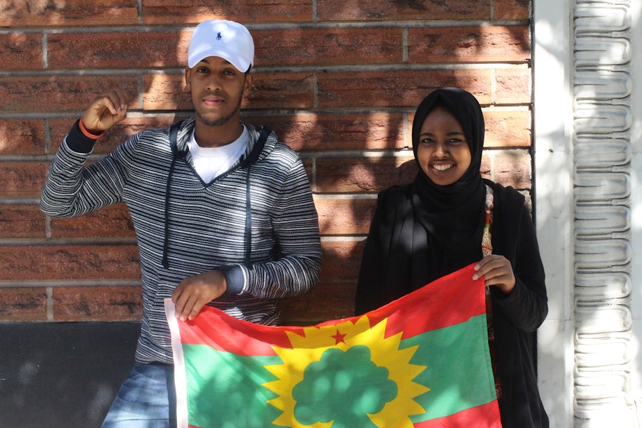 caption: Hosts Awal Ibrahim and Zubeyda Ahmed hold the Oromo flag.