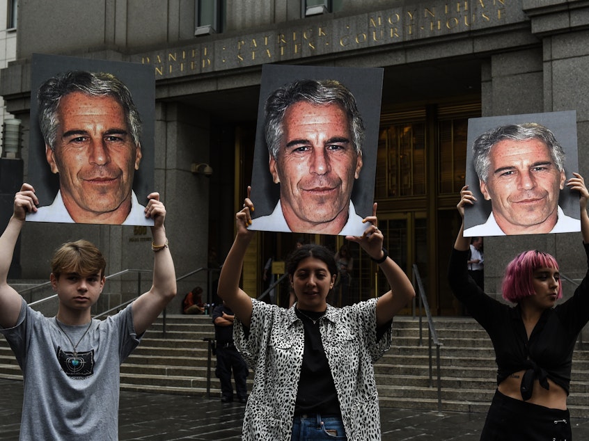 caption: A group of protesters hold photos of Jeffrey Epstein in front of a New York City federal courthouse in July 2019. A Southern District judge ruled this week that three lawsuits against banks that Epstein used can move forward.