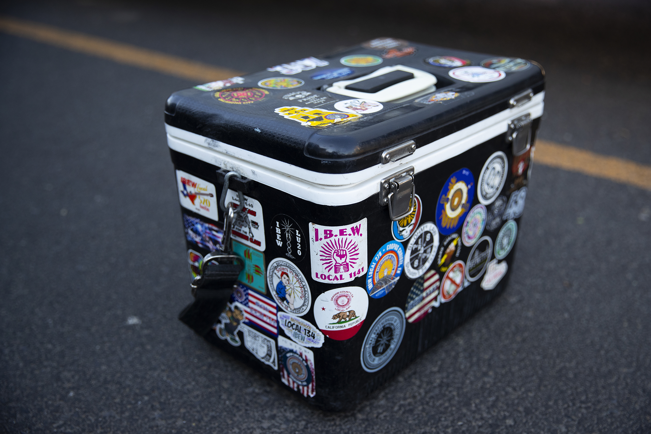 caption: Electrician Rudy Long’s lunch box is shown covered in IBEW stickers next to his truck outside of Brotherhood Night on Thursday, July 17, 2025, at Monkey N’Around Pizza in Quincy, Washington. 