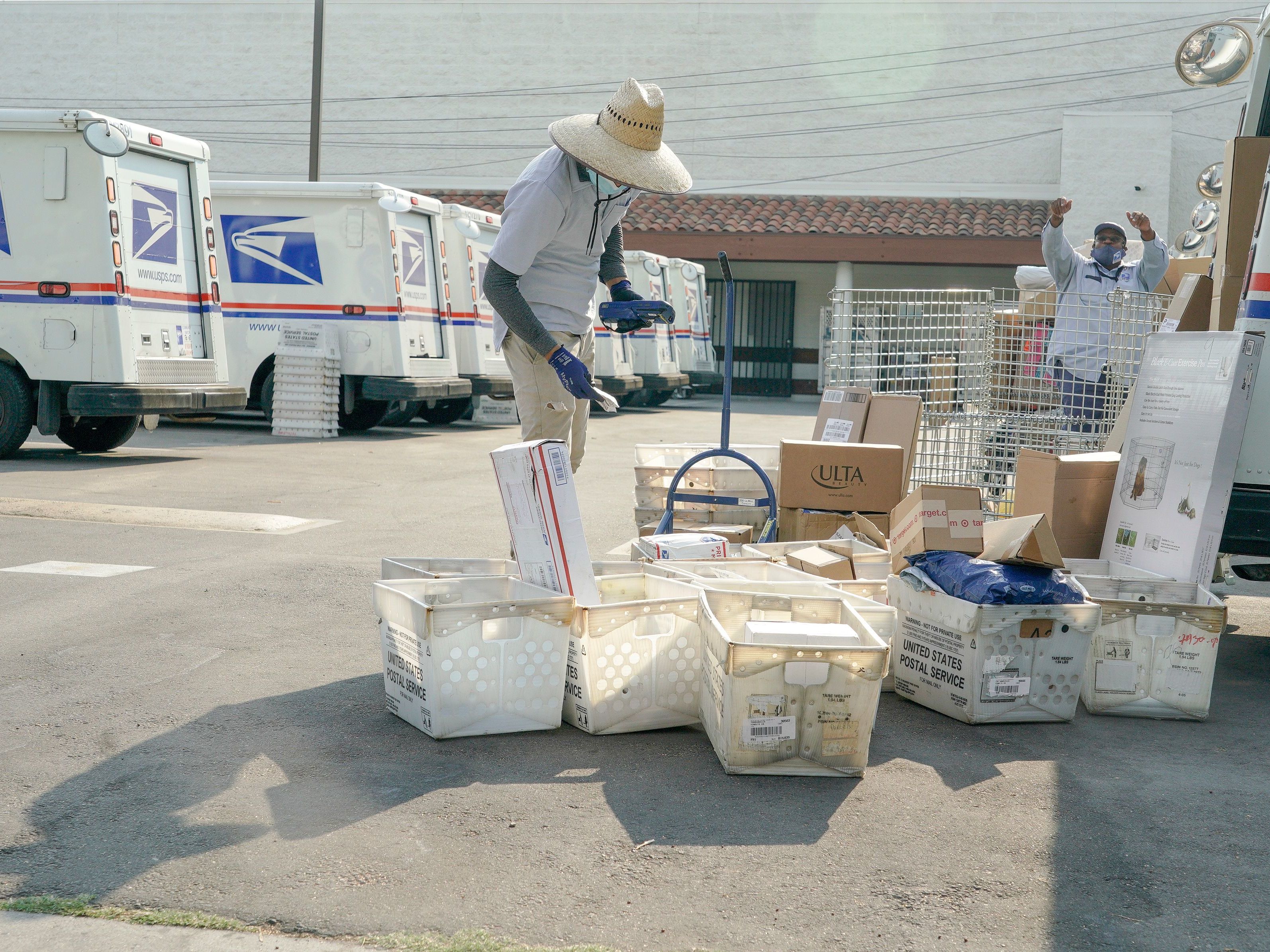 caption: Postal workers sort, load and deliver mail at a U.S. Postal Service location last month in Los Angeles.