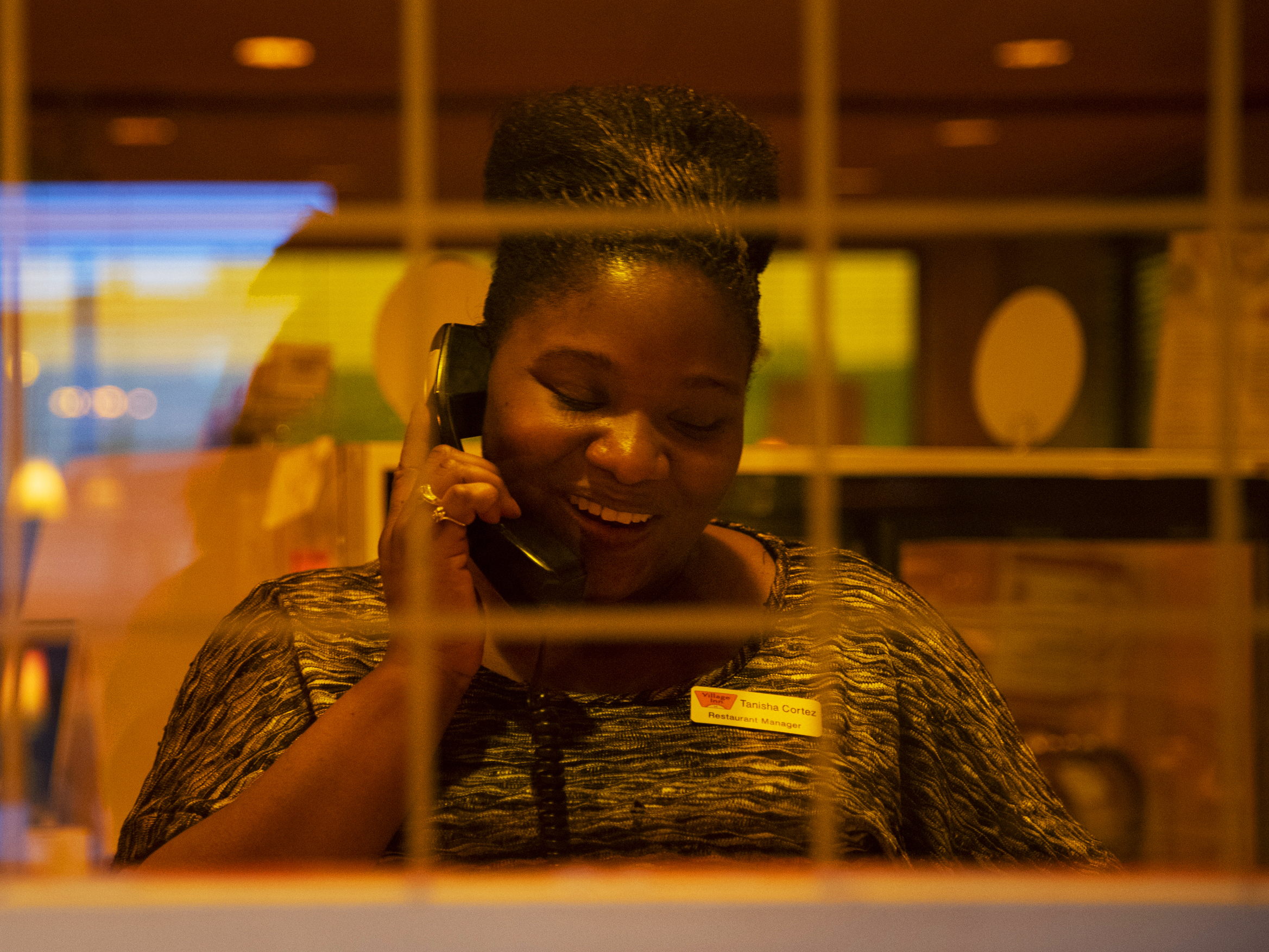 caption: Cortez answers a call from a customer. She's earning $2,000 more a year than she made at her old job.