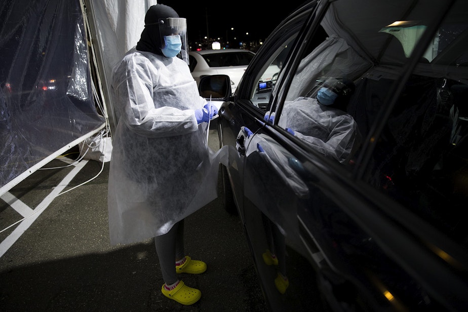 caption: Shakeitha Howard, a medical assistant at Carolyn Downs, prepares to administer the first dose of a Moderna Covid-19 vaccine for a healthcare worker on Thursday, January 7, 2021, at a drive-thru vaccine clinic in Renton. 