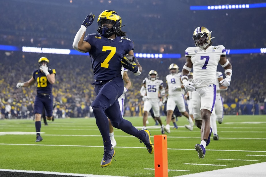 caption: Michigan running back Donovan Edwards celebrates after scoring against Washington during the first half of the national championship NCAA College Football Playoff game Monday, Jan. 8, 2024, in Houston. 