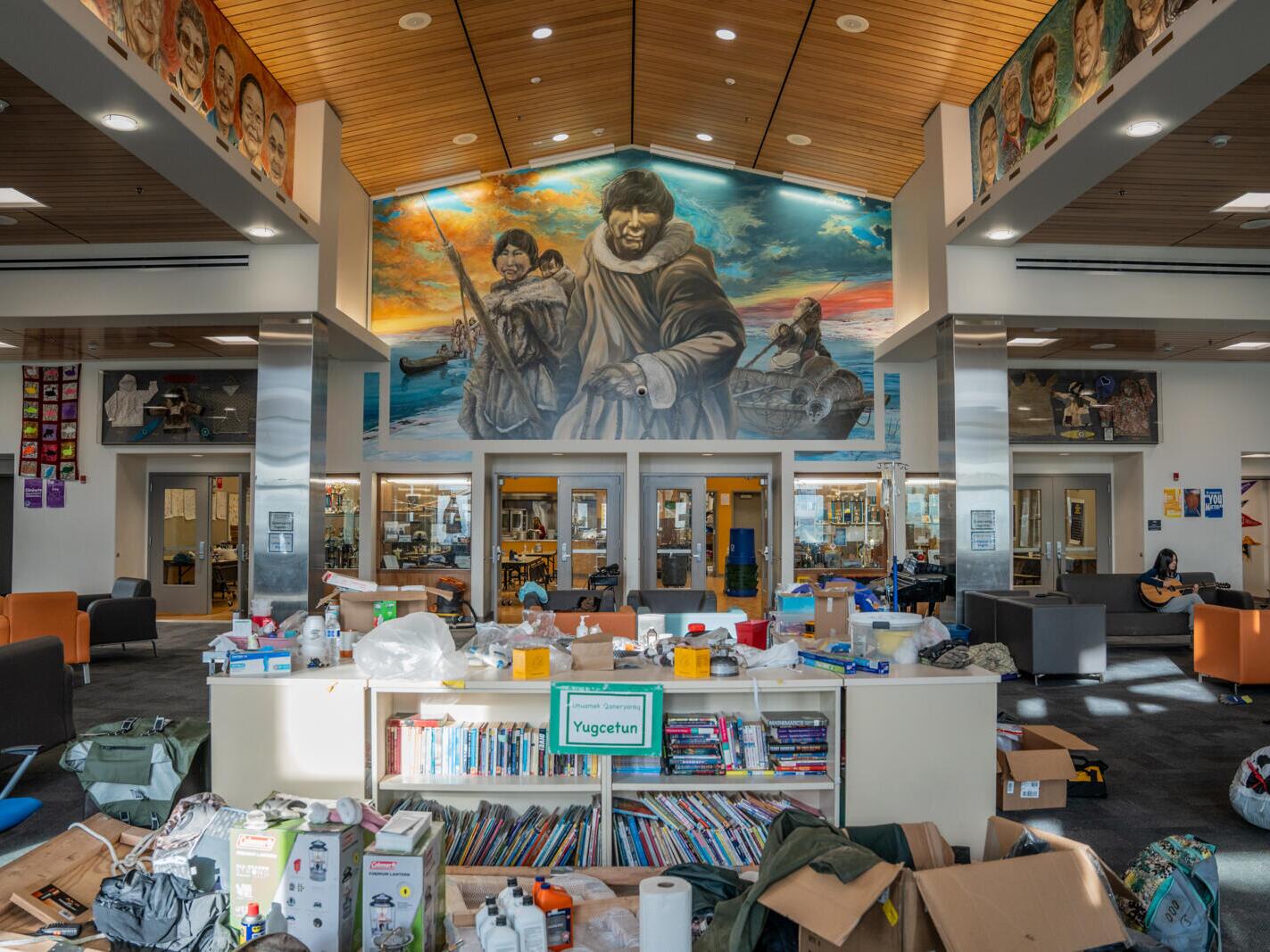 caption: Emergency supplies fill the lobby of the Chief Paul Memorial School in Kipnuk, Alaska. Nearly 700 people sheltered there for two days after ex-Typhoon Halong.