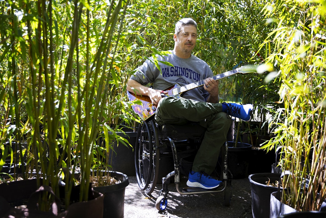 caption: Jon Schlueter is portrayed with his guitar at his home, and business, the Bamboo Collective Nursery, on Thursday, April 18, 2024, in Seattle’s Broadview neighborhood. 