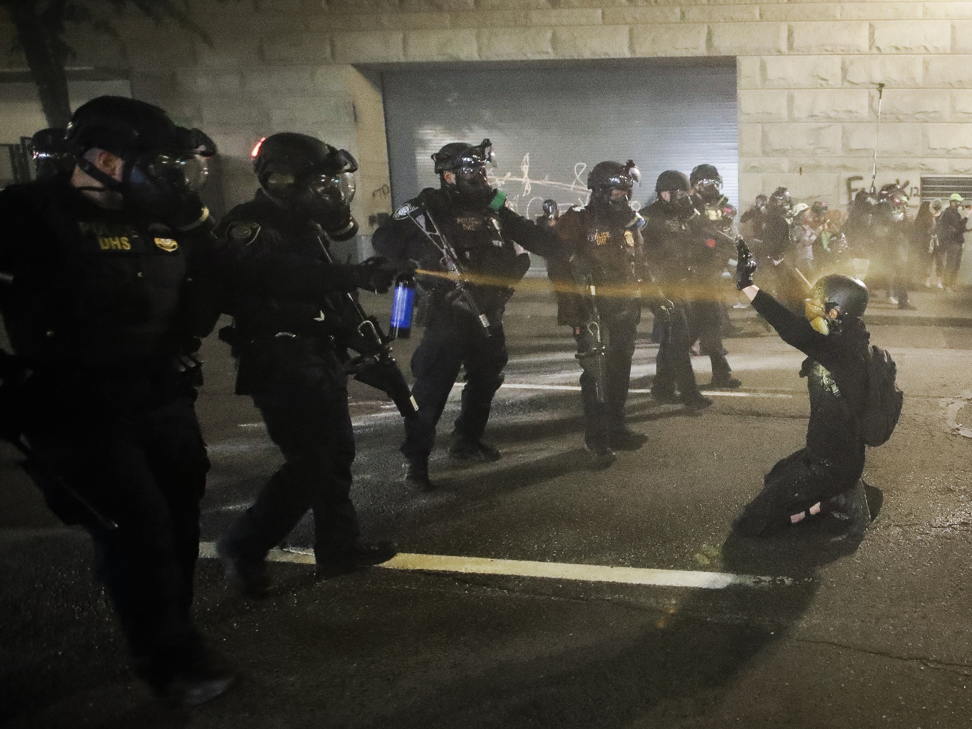 caption: A demonstrator is pepper-sprayed July 30 shortly before being arrested during a Black Lives Matter protest at the Mark O. Hatfield United States Courthouse in Portland, Ore.
