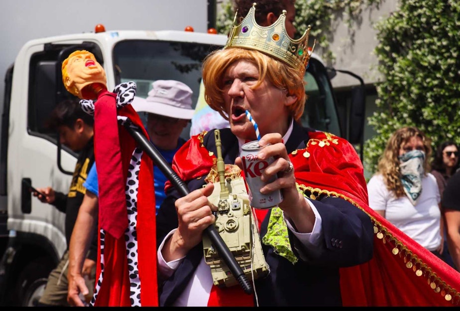 caption: A protester dressed as Donald Trump as a king in Seattle on June 14, 2025.