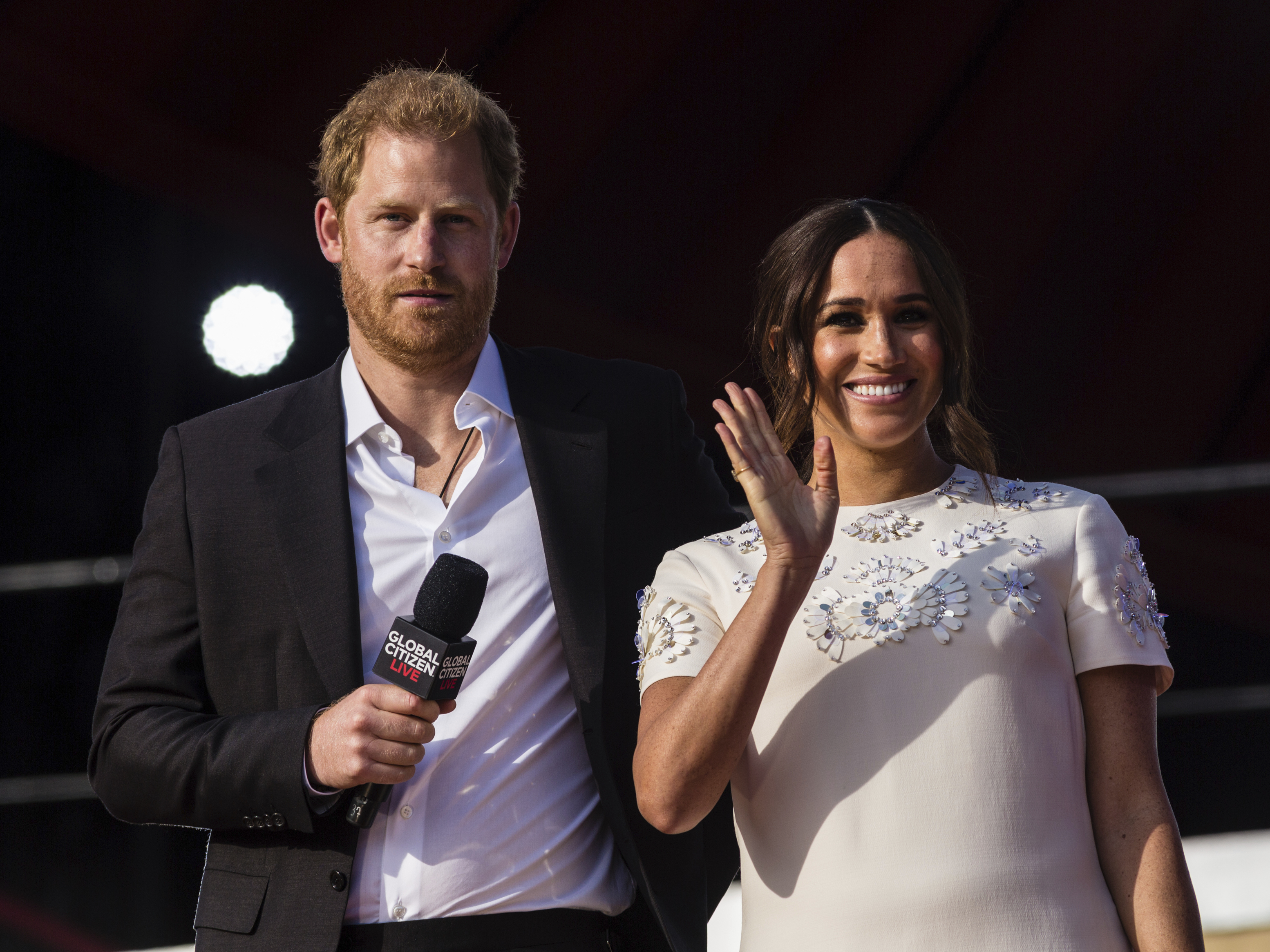 caption: Prince Harry and his wife Meghan speak during the Global Citizen festival, on Sept. 25, 2021, in New York. The couple visited Queen Elizabeth II at Windsor Castle on Thursday.