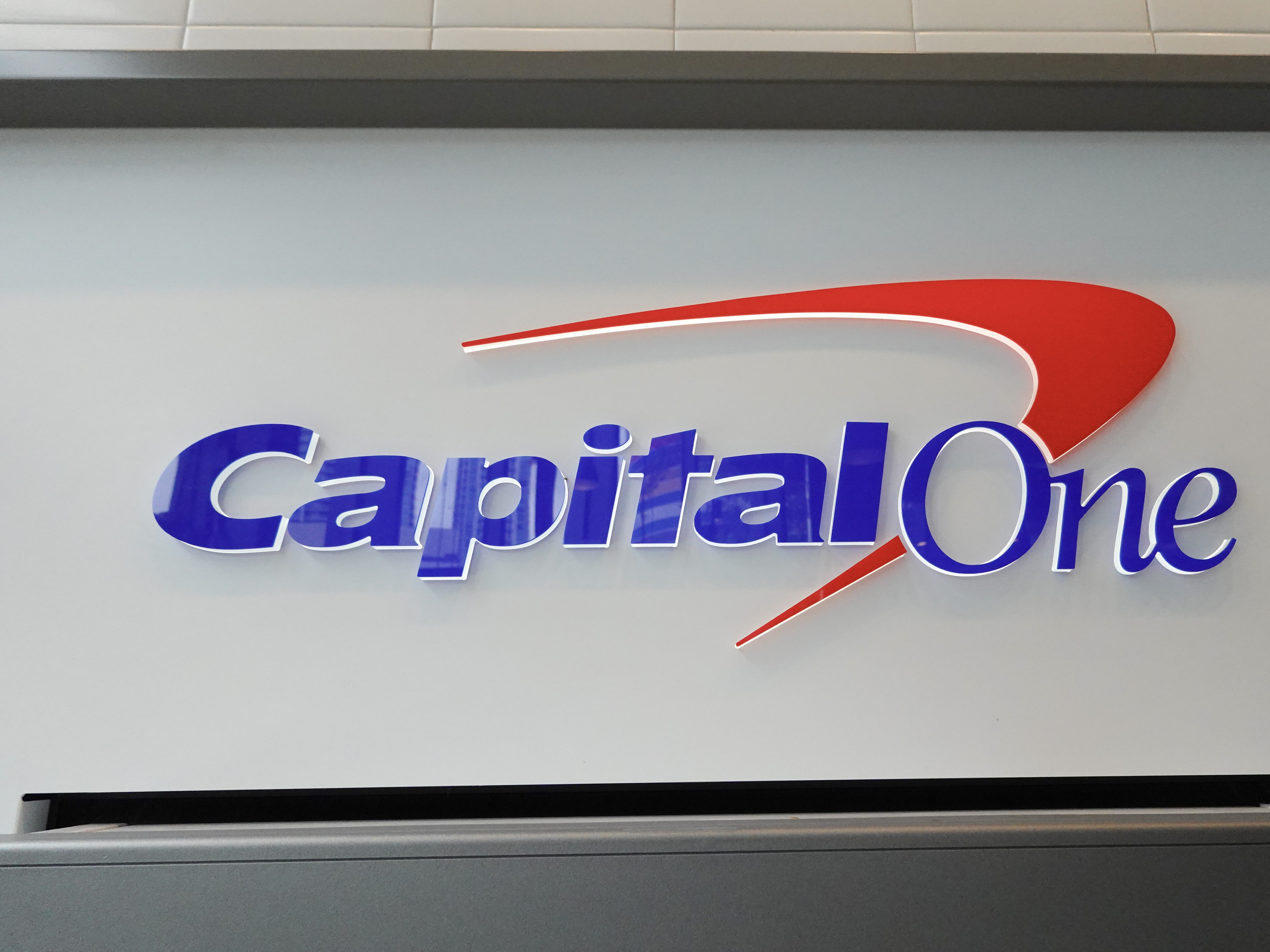 caption: A sign above an ATM at a Capital One Café on Feb.19, 2024, in Miami.