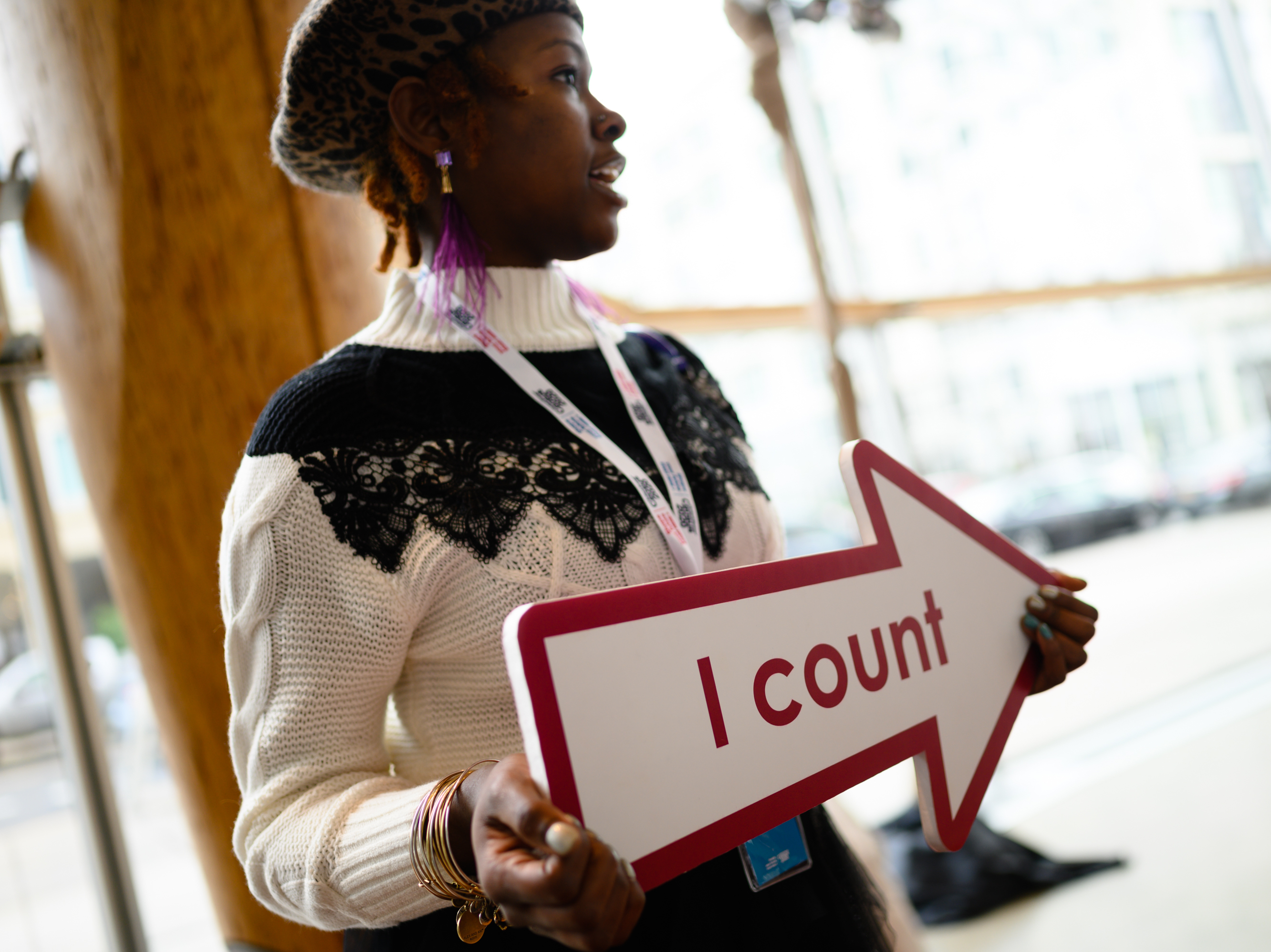 caption: Whitney Turner, an employee of the U.S. Census Bureau, holds an "I count" sign at a 2020 census advertising campaign event in Washington, D.C., in January 2020.