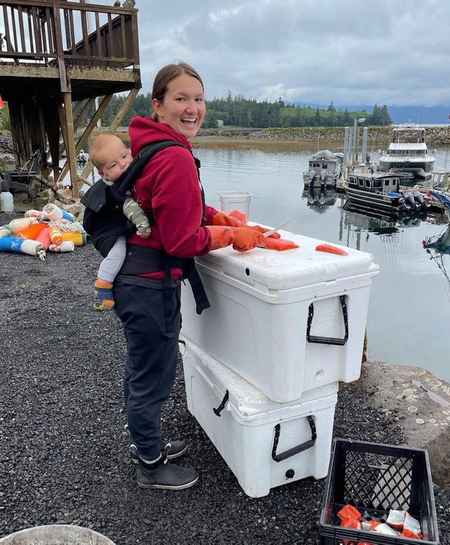 caption: Hannah Richter uses two beach-found coolers as a platform for cutting salmon in Craig, Alaska. 