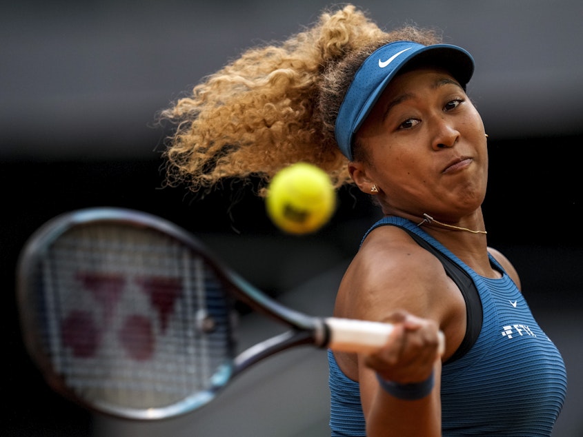 caption: Naomi Osaka of Japan returns the ball against Sara Sorribes Tormo of Spain during their match at the Mutua Madrid Open tennis tournament in Madrid, Spain, on May 1, 2022.