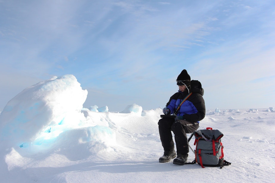 caption: Maria Coryell-Martin is an expeditionary artist capturing climate change. Here she paints atop an ice sheet.