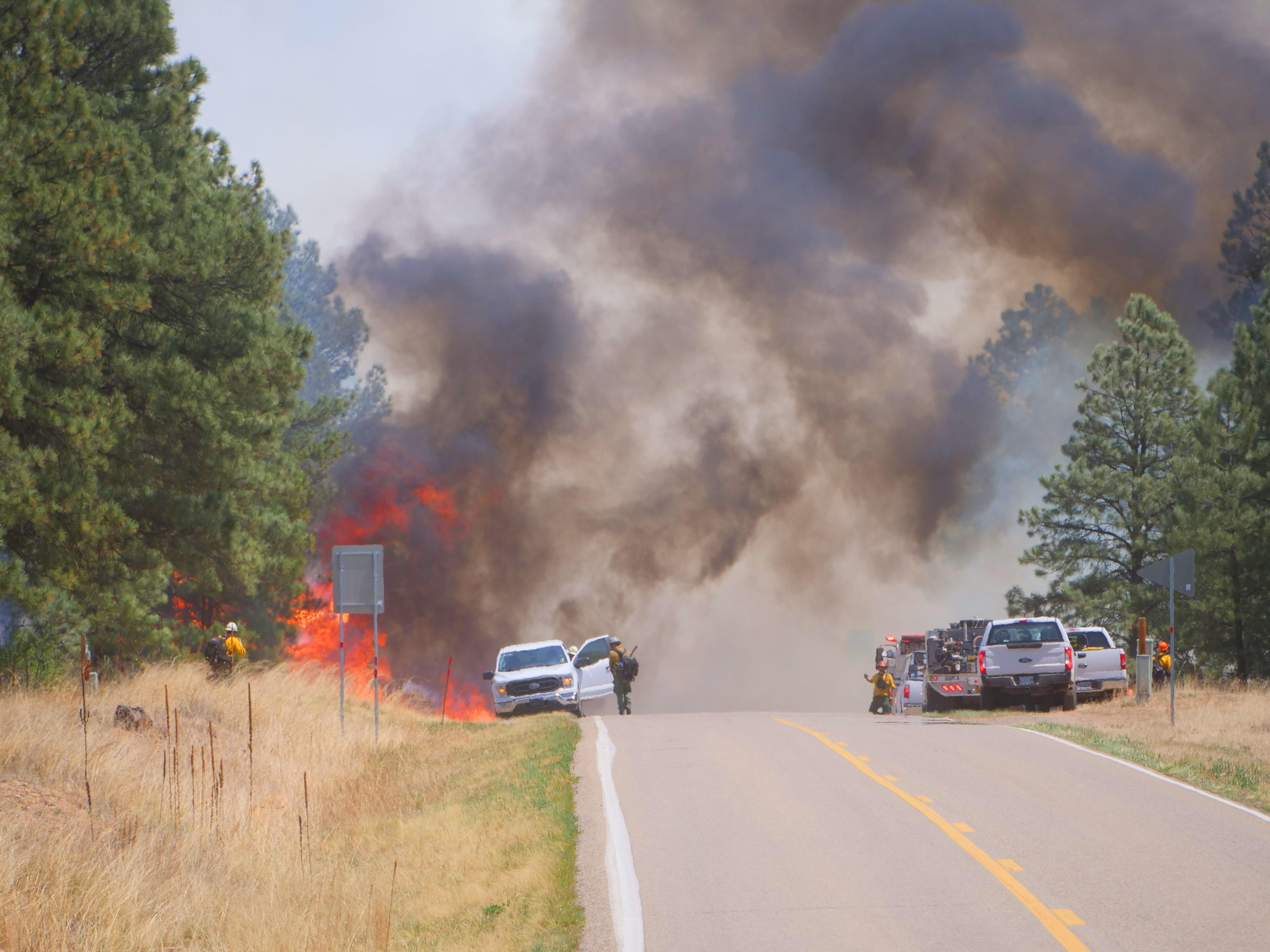 caption: The Hermits Peak fire approaches Highway 434 at Christmas Tree Canyon in New Mexico in 2022