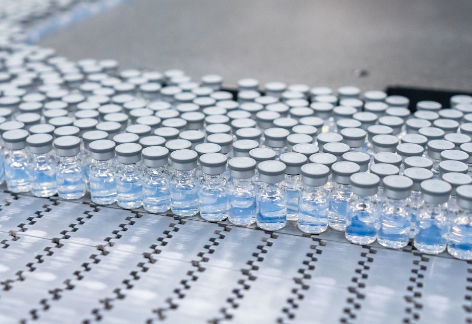 caption: Vials of the reformulated Pfizer-BioNTech COVID-19 booster move through production at a plant in Kalamazoo, Mich.