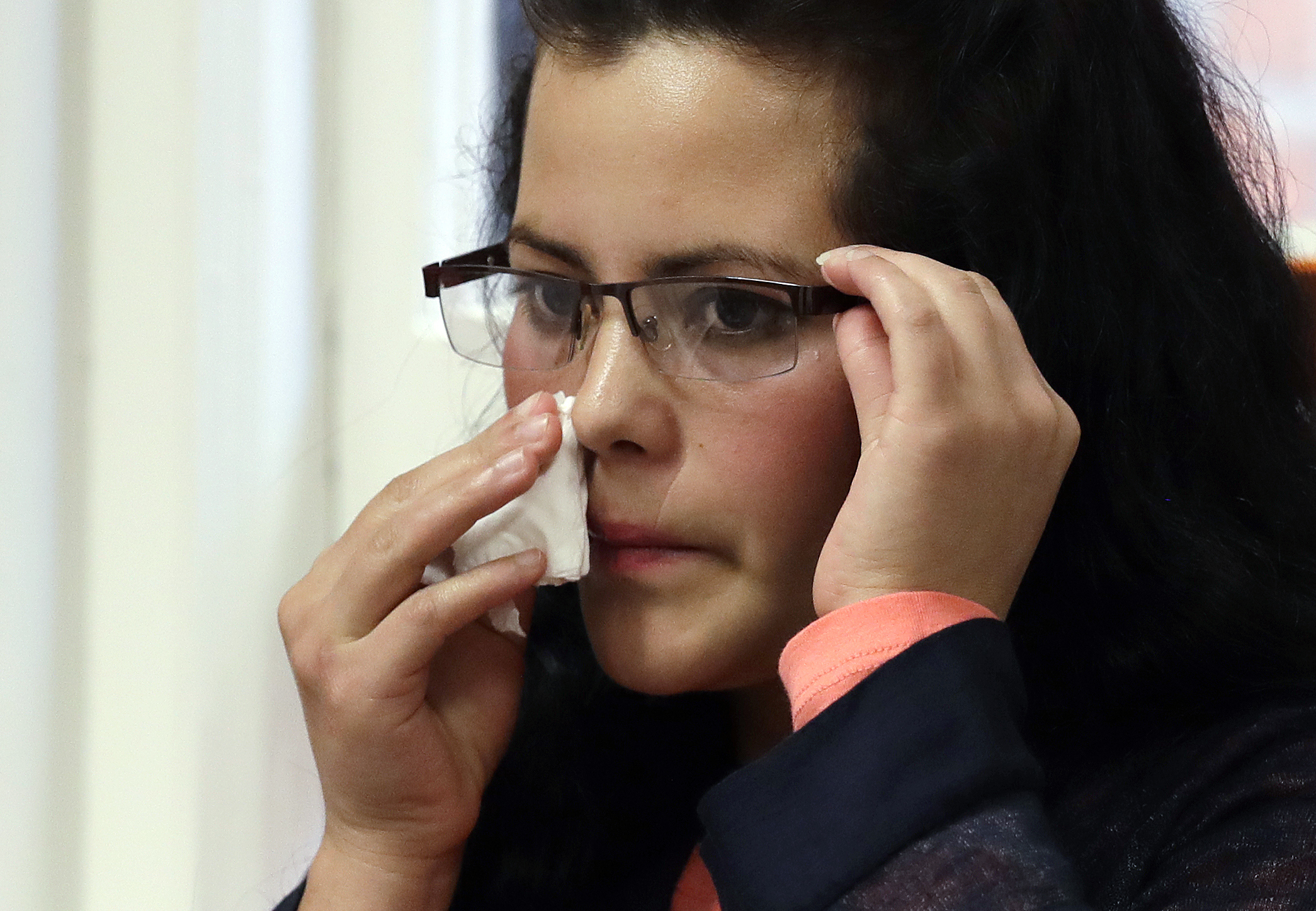 caption: Yolany Padilla, an asylum seeker separated from her 6-year-old son as part of the Trump Administration's 'zero tolerance' policy, wipes her face as she sits at a news conference Wednesday, July 11, 2018, in Seattle. 