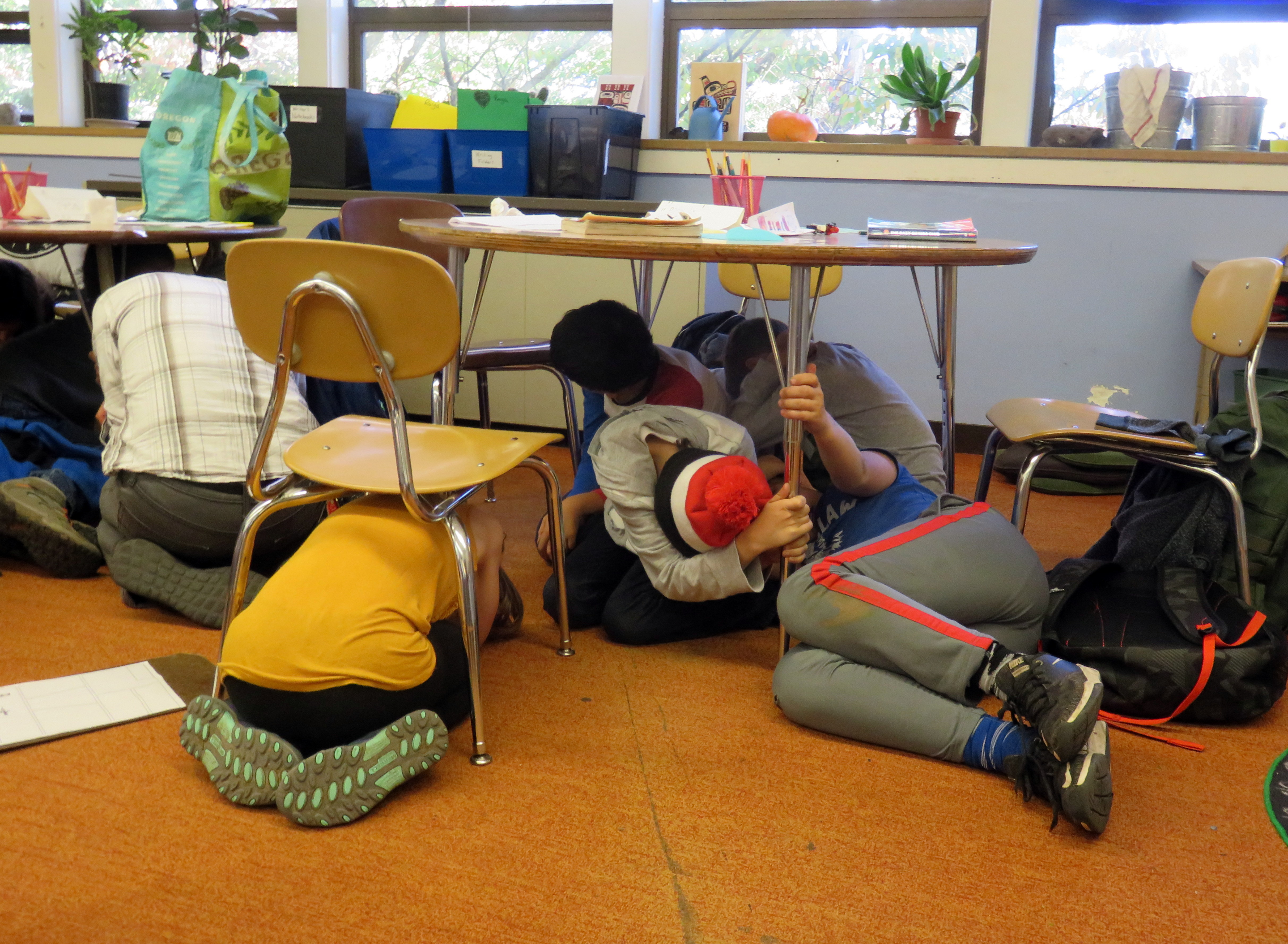 caption: Drop, cover and hold was just the beginning for a drill at Sunnyside Environmental K-8 School last Wednesday.