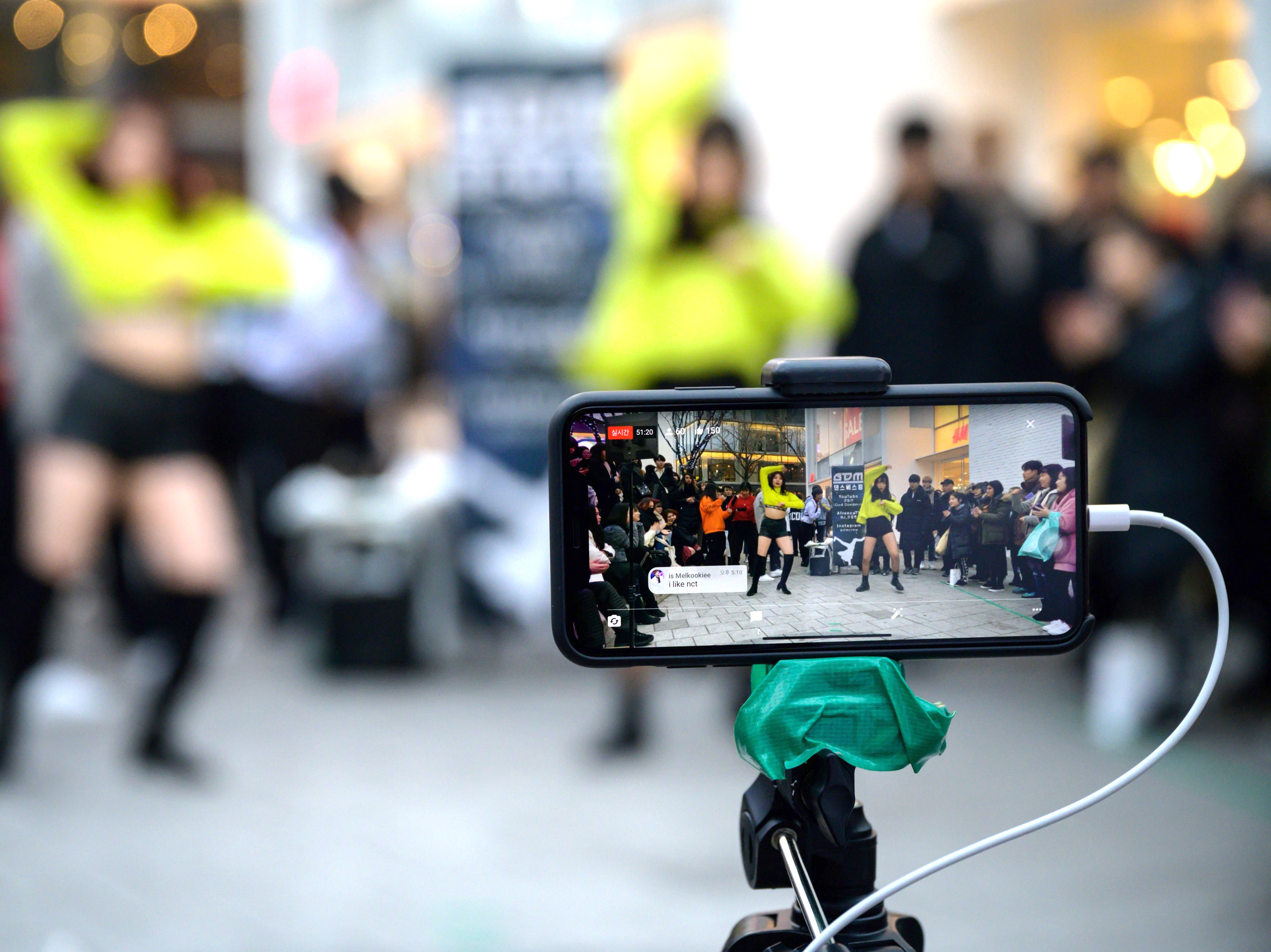 caption: An aspiring K-pop group performs in the Hongdae district of Seoul on Jan. 5, 2020.
