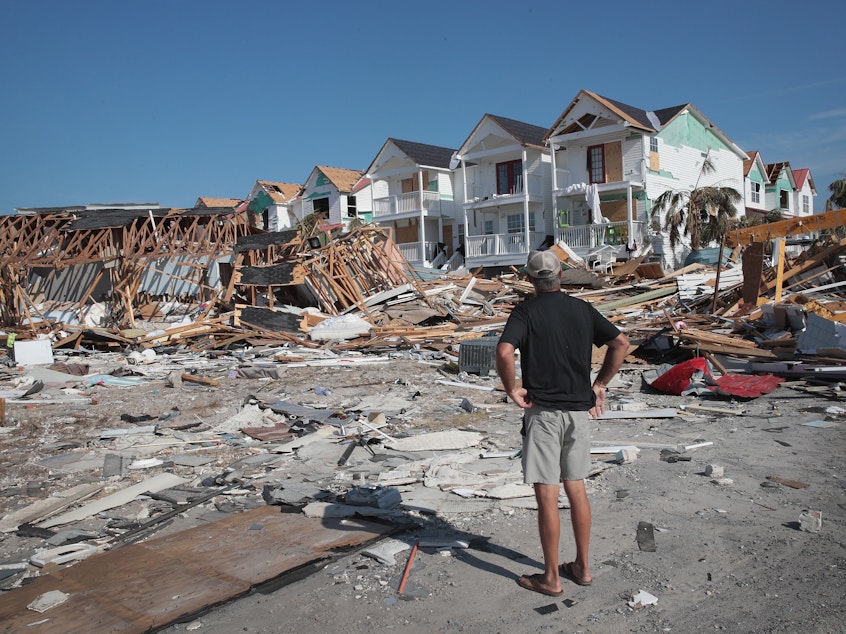 caption: A resident of Mexico Beach, Fla., looks over damage caused to the Florida panhandle by Hurricane Michael in October 2018.