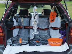 caption: A car is open at a trunk-or-treat in 2014. The events allow children to collect candy from trunks of cars gathered in parking lots.