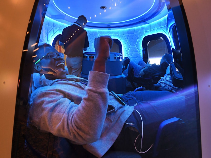 caption: Participants sit a Blue Origin space simulator during a conference on robotics and artificial intelligence in Las Vegas on June 5, 2019. On Saturday, Blue Origin announced that an unidentified bidder will pay $28 million for a suborbital flight on the company's New Shepard vehicle.