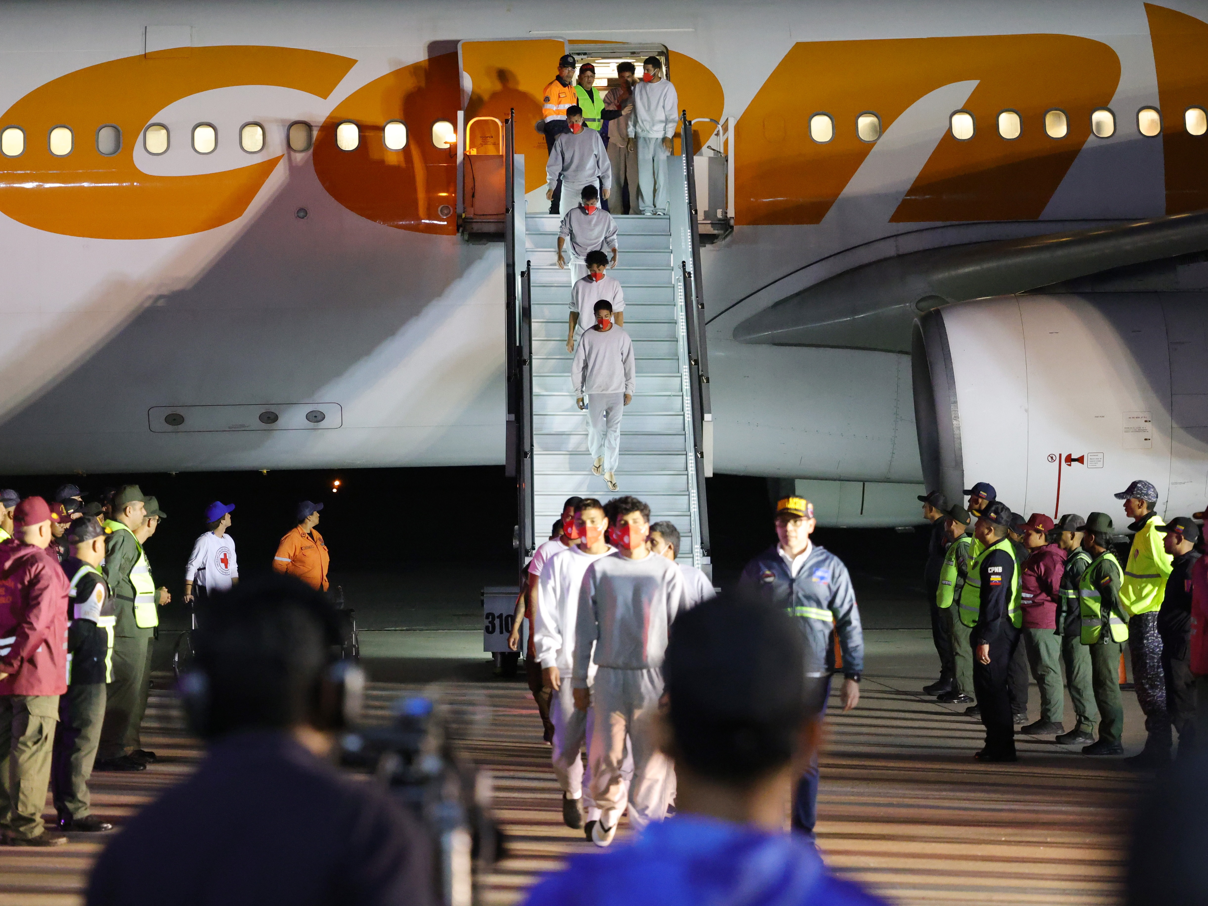 caption: Venezuelan migrants deported by the U.S. disembark from a plane at Simon Bolivar International Airport in La Guaira, Venezuela on Feb. 20.
