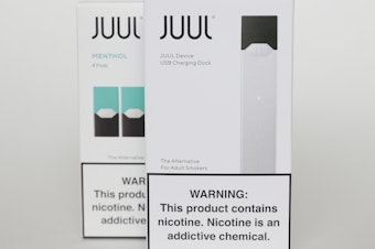 caption: Packaging for an electronic cigarette and menthol pods from Juul Labs is displayed on Feb. 25, 2020, in Pembroke Pines, Fla. In a deal announced Tuesday, Juul will pay nearly $440 million to settle a two-year investigation by 33 states into the marketing of its high-nicotine vaping products.