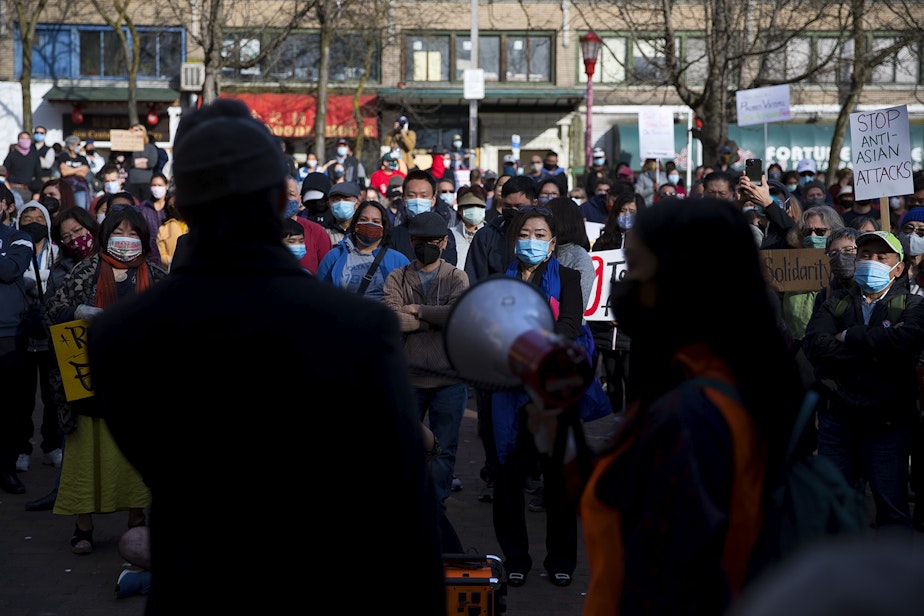 caption: Hundreds gather to listen to speakers during the 'We Are Not Silent' rally and march against hate and violence toward the Asian American Pacific Islander community on Saturday, March 13, 2021, at Hing Hay Park in Seattle.
