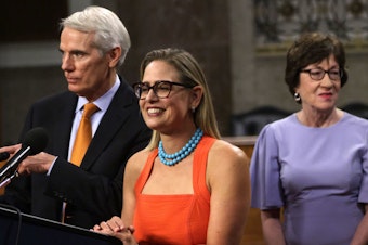 caption: Sen. Rob Portman, R-Ohio (left) and Sen. Kyrsten Sinema, D-Ariz., answer questions from the press as Sen. Susan Collins, R-Maine, looks on during a news conference about the bipartisan infrastructure deal on July 28.