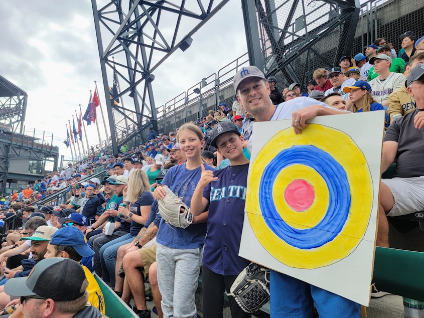 caption: Ben Kaufman with his kids, Ellen and Freddy, in the left-field bleachers during the Home Run Derby in Seattle on Monday, July 10, 2023.