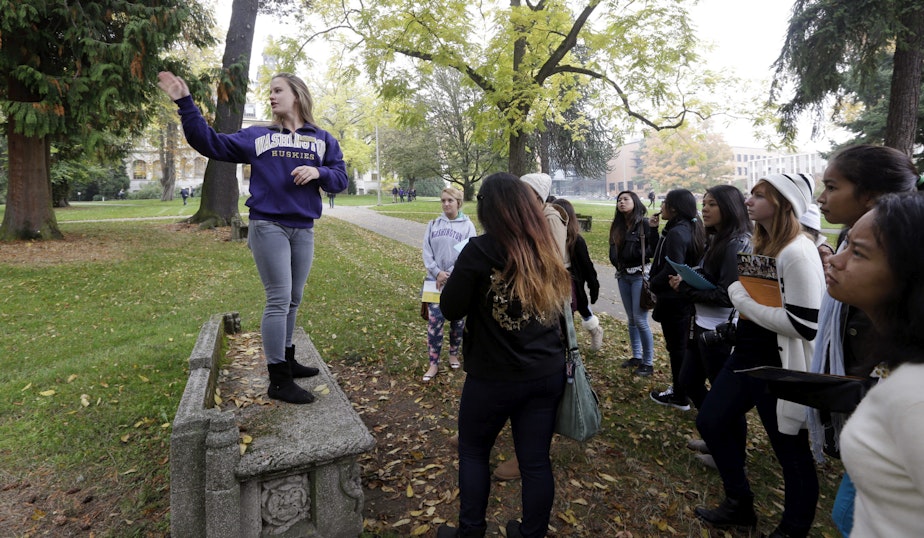 caption: In this 2013 photo, University of Washington sophomore Megan Herndon, of Kailua, Hawaii, stands on a bench as she leads high school students on a tour of the campus in Seattle. CREDIT: ELAINE THOMPSON/AP