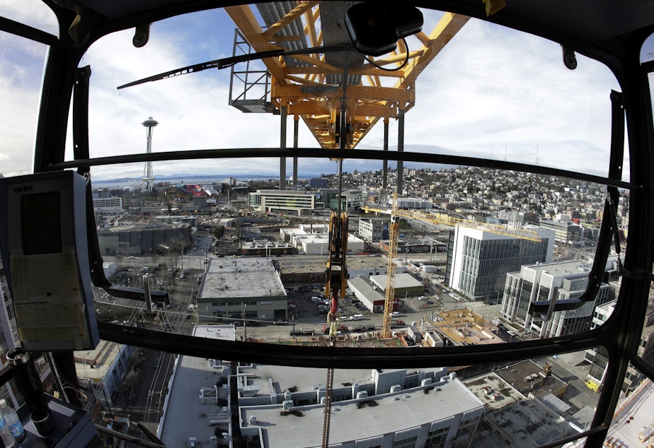 caption: In this Feb. 10, 2015, photo, Seattle's Space Needle and several construction cranes are shown from the operating cab of a 238-foot high construction crane working on a new building in Seattle's South Lake Union neighborhood.