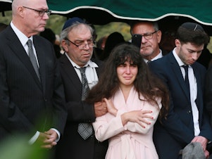 caption: Family members attend the burial service for Lori Kaye, who was killed in the Chabad of Poway synagogue shooting on Saturday. The parents of the man accused in the shooting have condemned the attack as shocking and evil.