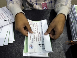 caption: A Harris County election worker prepares mail-in ballots to be sent to Texas voters ahead of the 2020 election. After a GOP-backed law in 2021 changed rules for mail ballots, rejections spiked in this year's state primaries.