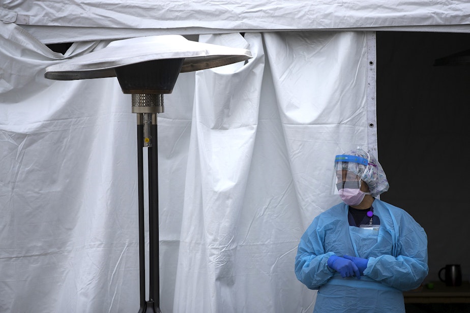 caption: A UW Medicine nurse waits for patients to arrive to be tested for coronavirus on Tuesday, March 17, 2020, at the University of Washington Northwest Outpatient Medical Center drive-through testing area on Meridian Avenue North in Seattle.