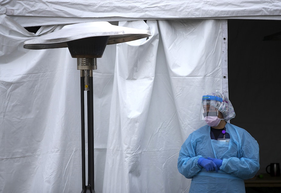 caption: A UW Medicine nurse waits for patients to arrive to be tested for coronavirus on Tuesday, March 17, 2020, at the University of Washington Northwest Outpatient Medical Center drive-through testing area on Meridian Avenue North in Seattle.