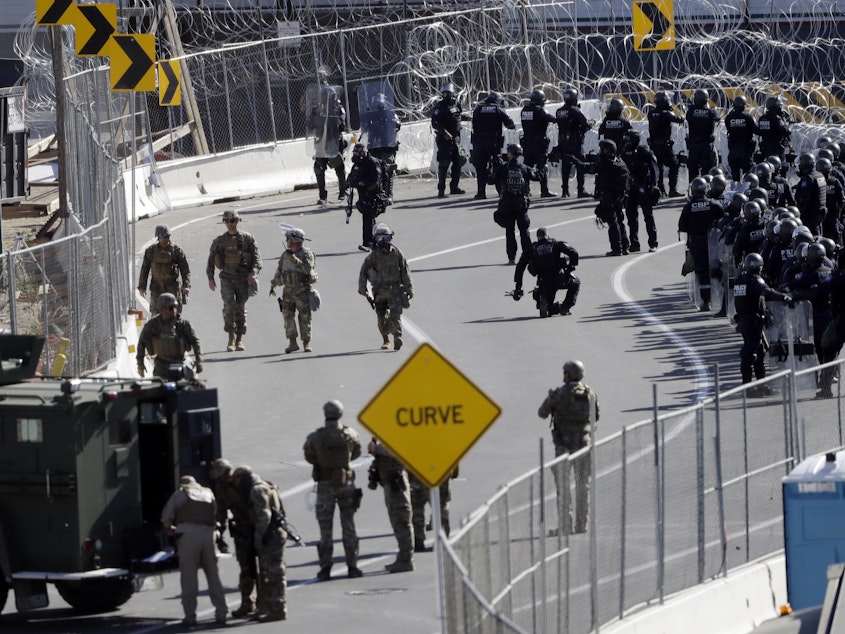 caption: Military personnel and Customs and Border Protection officers gather at the San Ysidro Port of Entry in San Diego. The number of immigrants in the U.S. without legal status has declined to its lowest level in more than a decade, according to a new report released Tuesday.