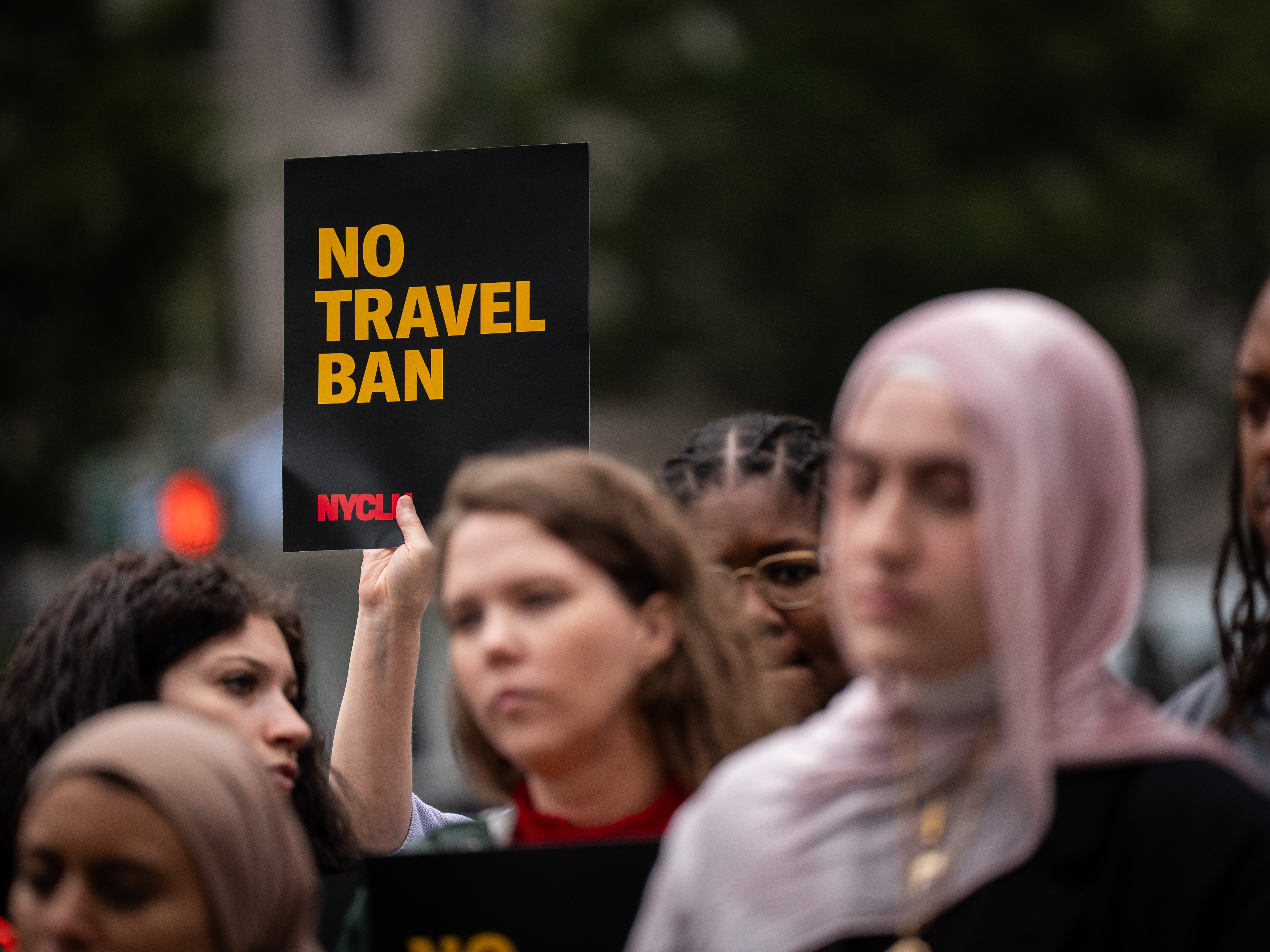 caption: A rally in New York on June 9 protested President Donald Trump's new travel ban, which restricts entry to the United States for citizens from 19 countries.