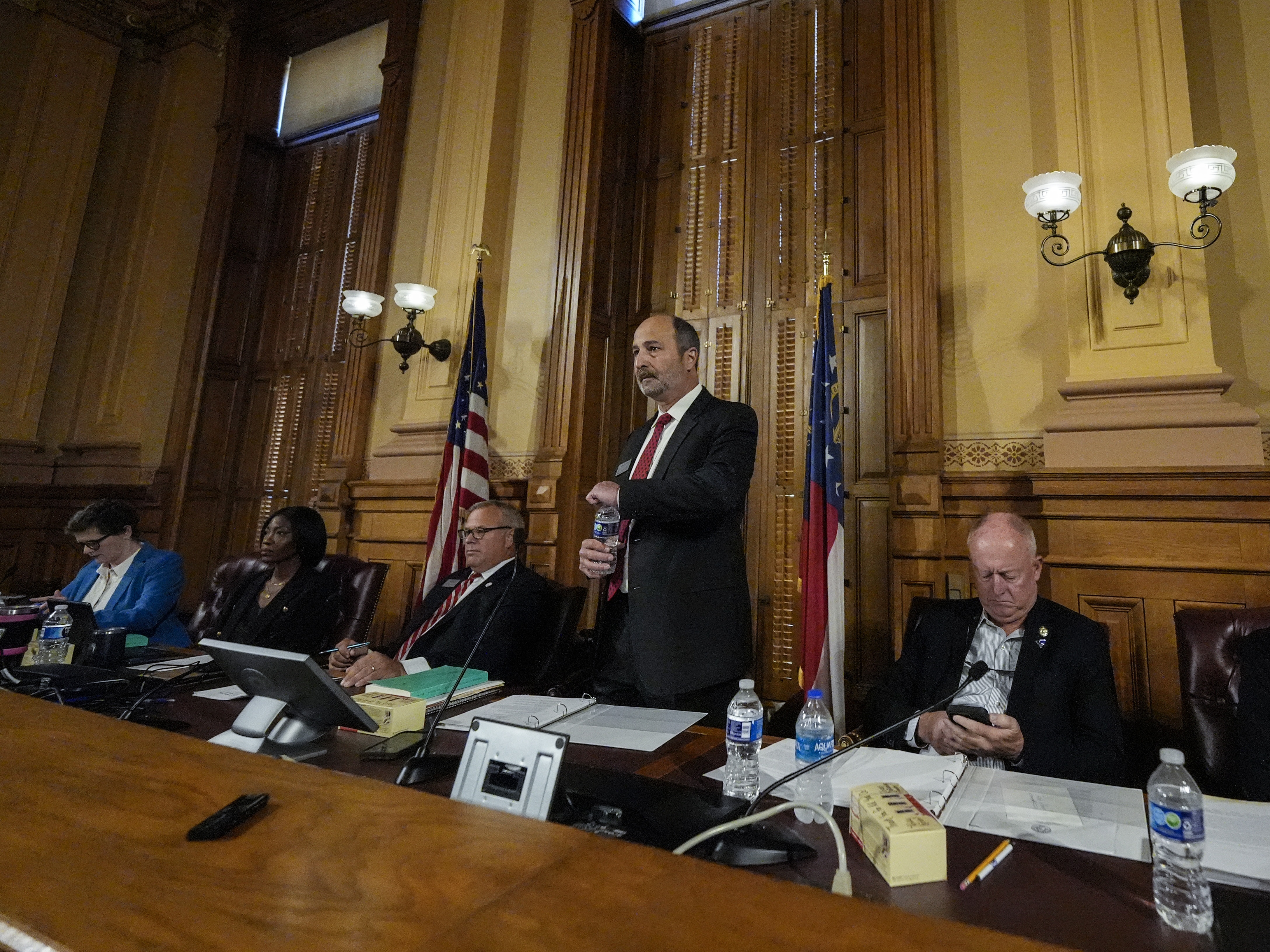 caption: Georgia's State Election Board members meet to discuss proposals for election rule changes at the state capitol in Atlanta Friday.