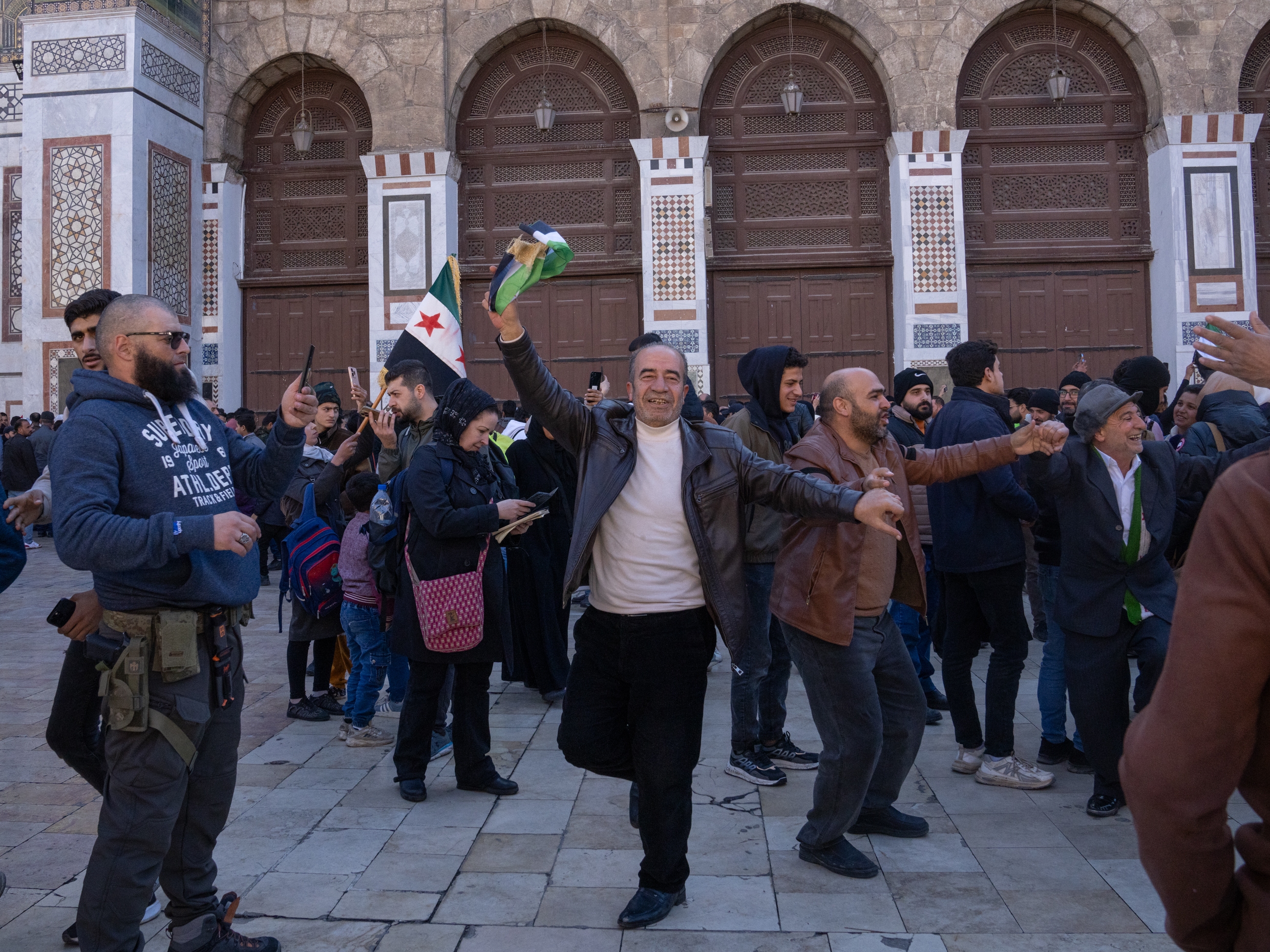 caption: Men dance outside the Ummayad Mosque in Damascus, Syria, on Friday.