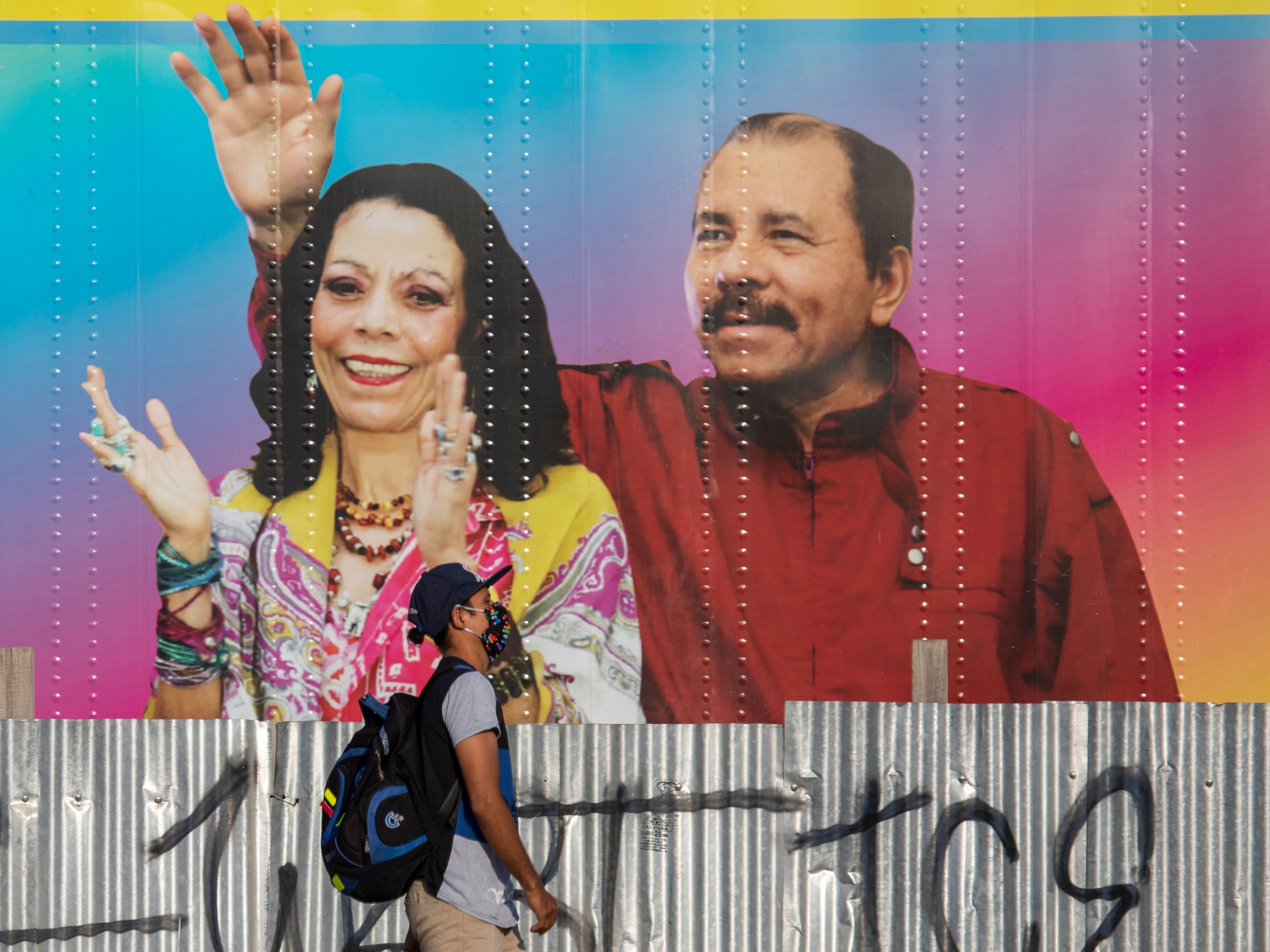 caption: A man walks by a mobile health clinic displaying a picture of Nicaraguan President Daniel Ortega (right) and his wife and vice president, Rosario Murillo, in Managua on April 14, 2020. The government claims to be successfully combating the pandemic but health workers and critics say the toll is likely higher.