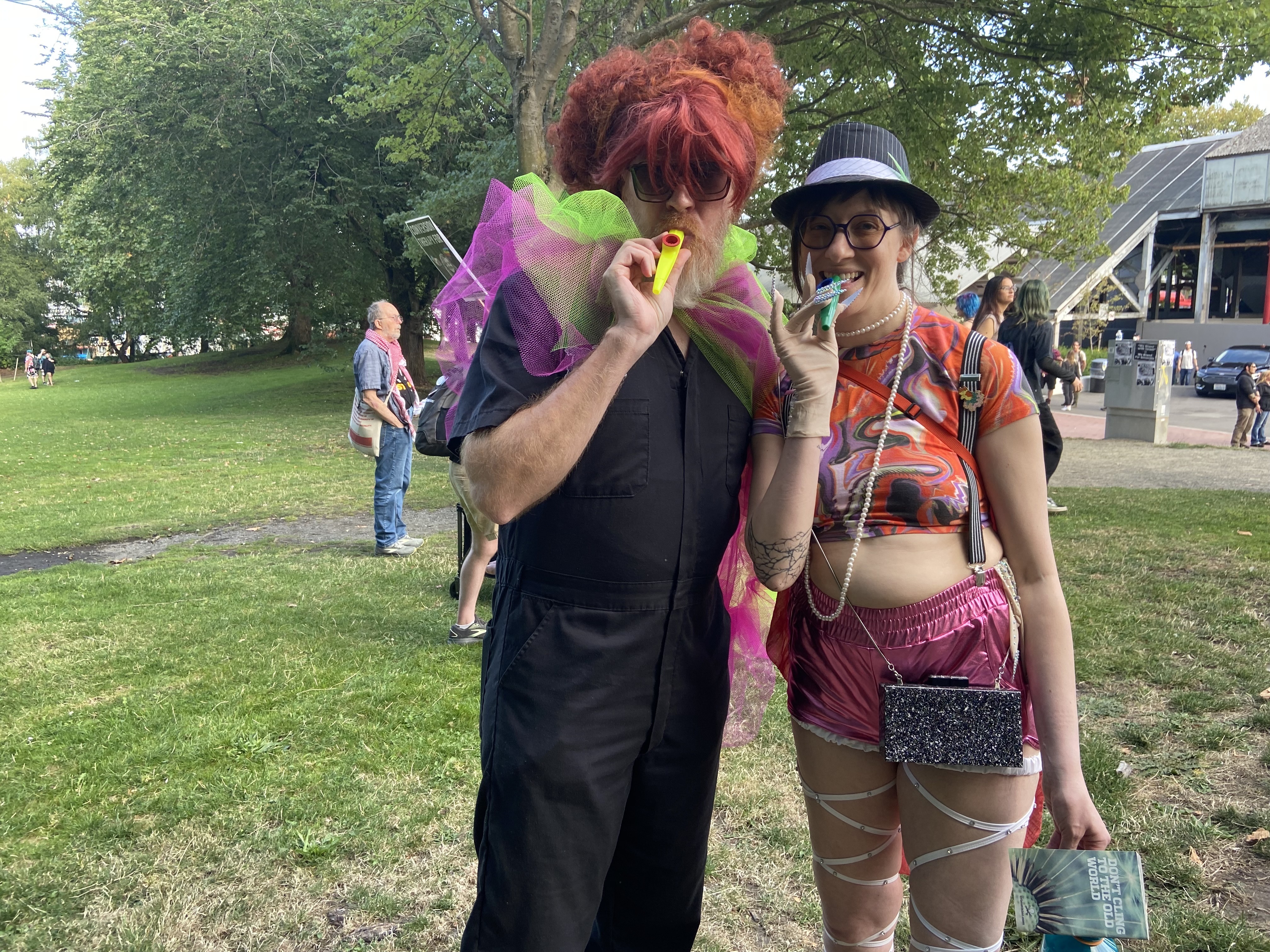 caption: James Watkins (left) and his partner, Caitlin Watkins (right) joined a Chappell Roan themed kazoo karaoke protest at Seattle’s Gas Works Park on Saturday. 