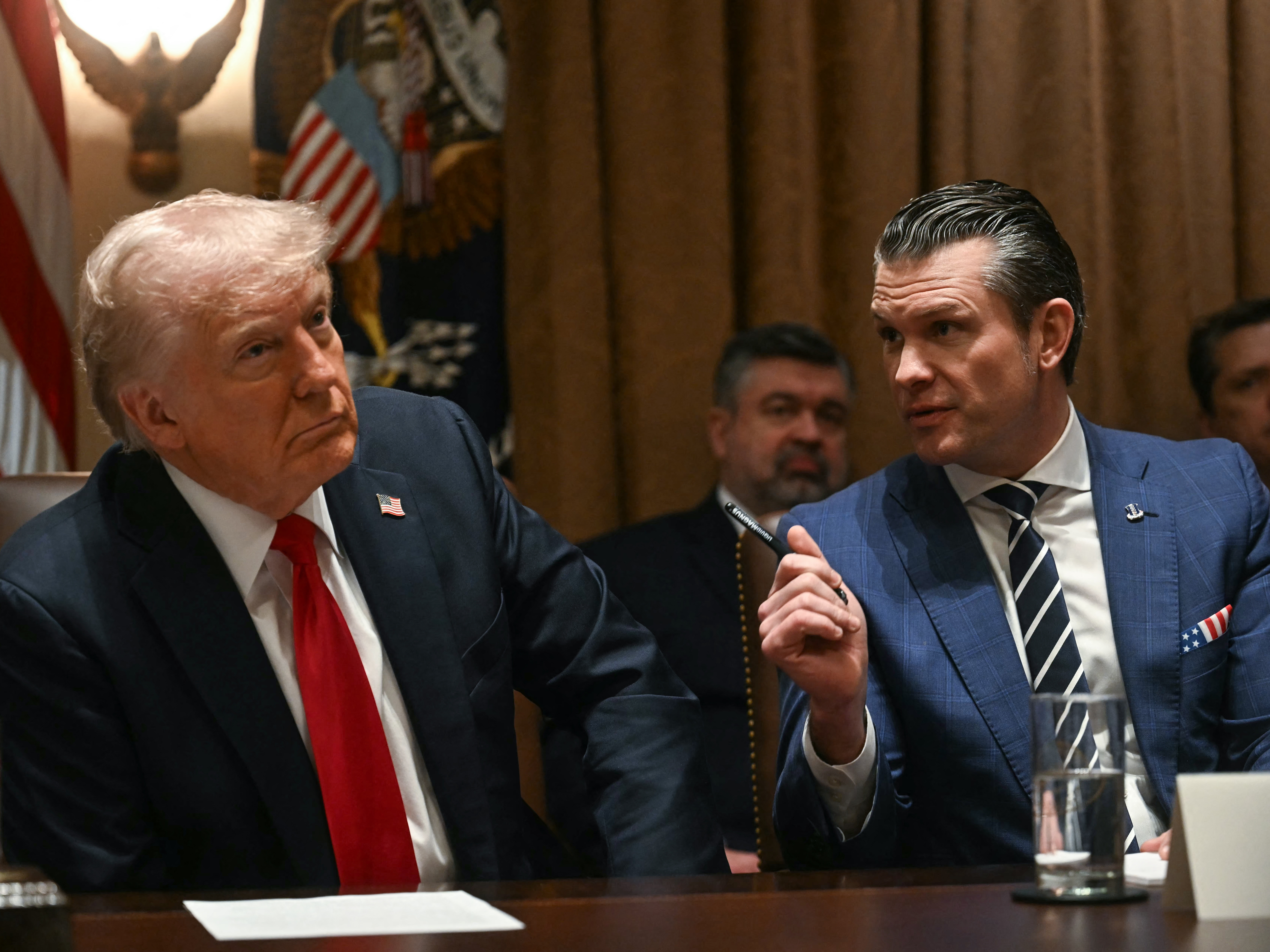 caption: President Trump looks on as Defense Secretary Pete Hegseth speaks during a cabinet meeting at the White House on Wednesday.
