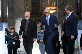 caption: Washington Gov. Jay Inslee walks through the Capitol building in Olympia, en route to deliver his annual State of the State address, Jan. 10, 2023.