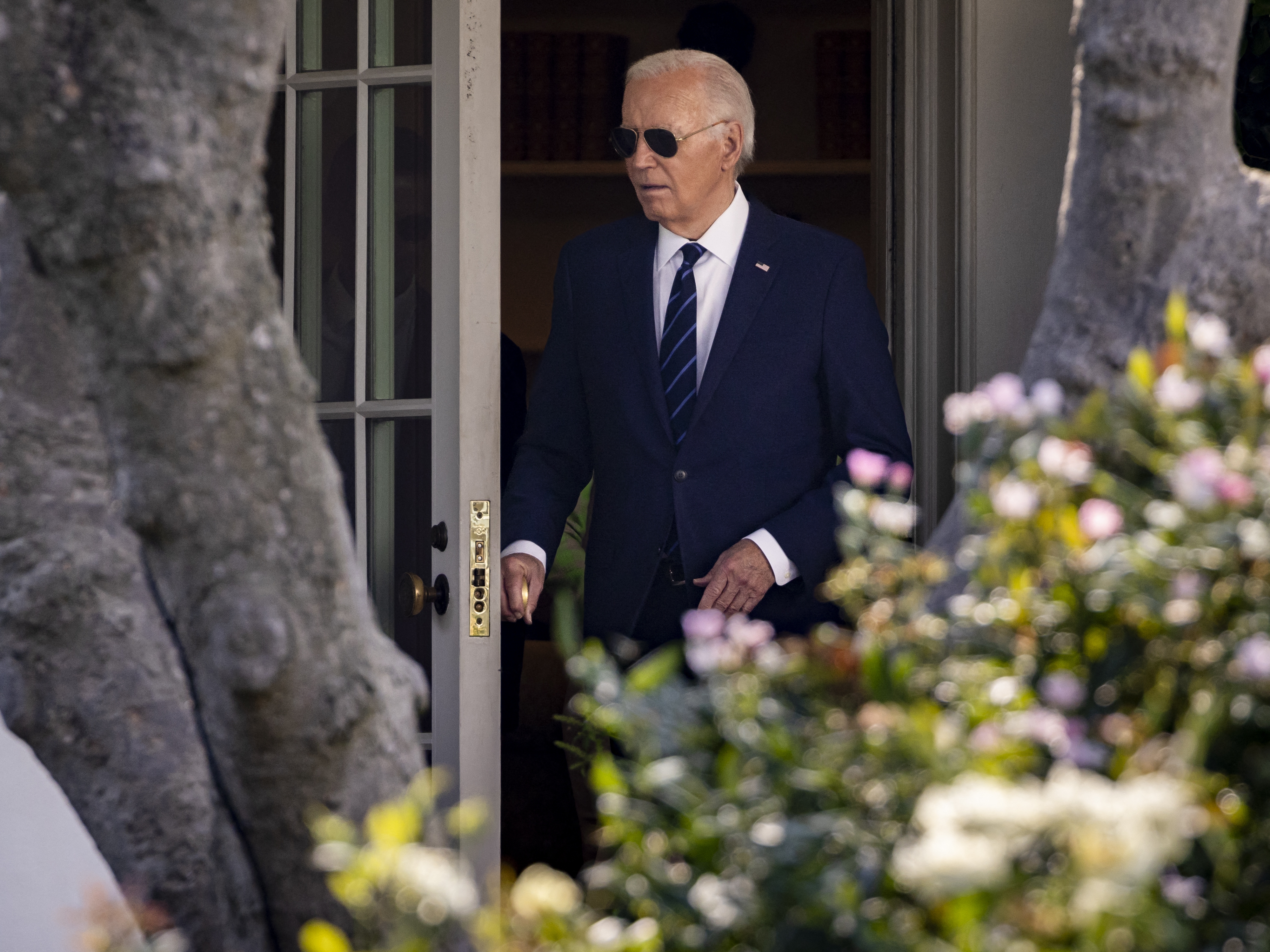 caption: President Biden walks out of the Oval Office towards the South Lawn of the White House on July 15 as he left to campaign in Las Vegas.