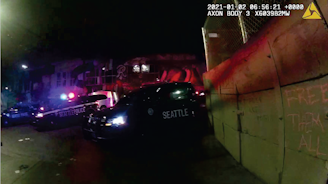 caption: Still image from the bodycam footage of a Seattle Police officer on Jan. 1, 2021, that shows the concrete barrier, some of the protesters' statements, and the police response.