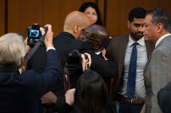 caption: U.S. Sen. Cory Booker, D-N.J., hugs Johnny Brown, the father of Judge Ketanji Brown Jackson, after Booker spoke Wednesday during the Senate Judiciary Committee confirmation hearing on her nomination to become a justice on the U.S. Supreme Court.